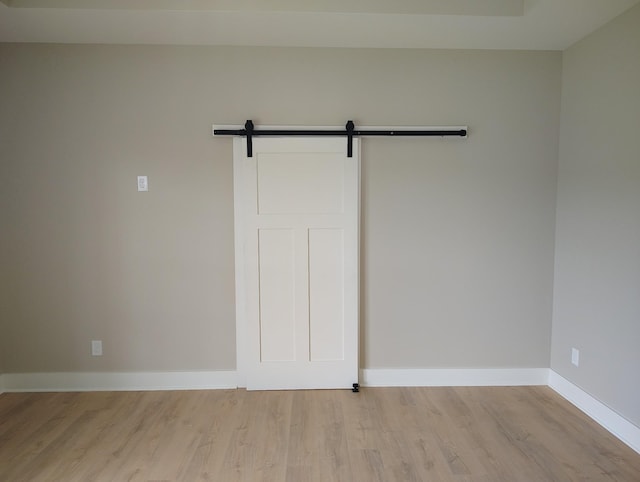 1452 Purtle Rd, Lafayette, TN 37083 - spare room with light wood-type flooring, a barn door, and baseboards