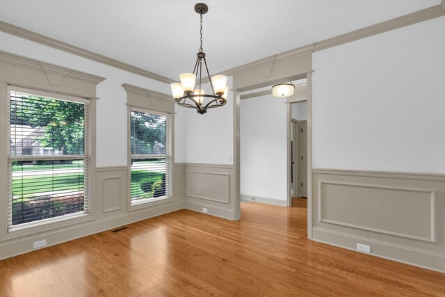 2726 Wynthrope Hall Dr, Murfreesboro, TN 37129 - unfurnished dining area featuring a chandelier, wainscoting, light wood-type flooring, crown molding, and a decorative wall