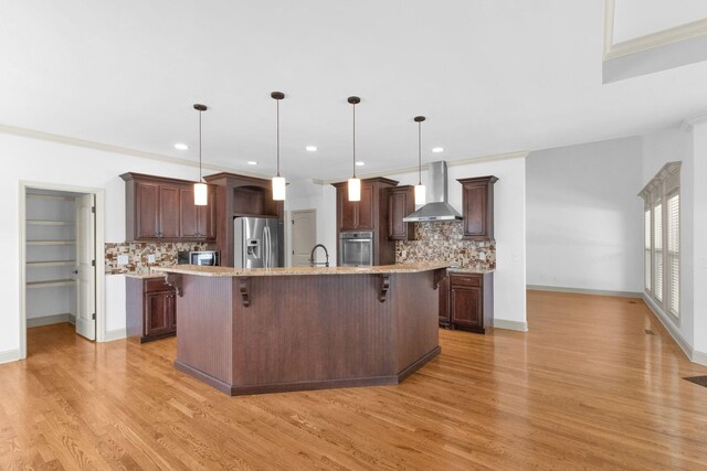 2726 Wynthrope Hall Dr, Murfreesboro, TN 37129 - kitchen featuring wall chimney exhaust hood, stainless steel appliances, decorative backsplash, a kitchen bar, and recessed lighting