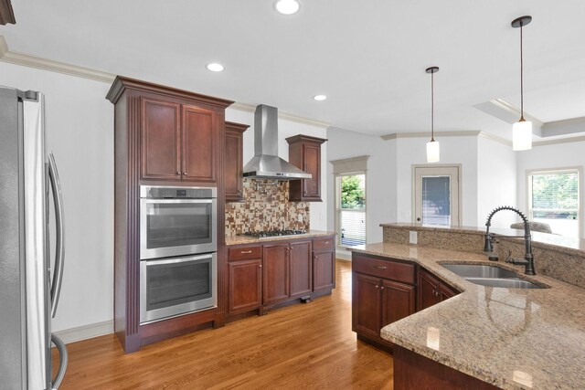 2726 Wynthrope Hall Dr, Murfreesboro, TN 37129 - kitchen with stainless steel appliances, a sink, wall chimney exhaust hood, light wood-style flooring, and backsplash