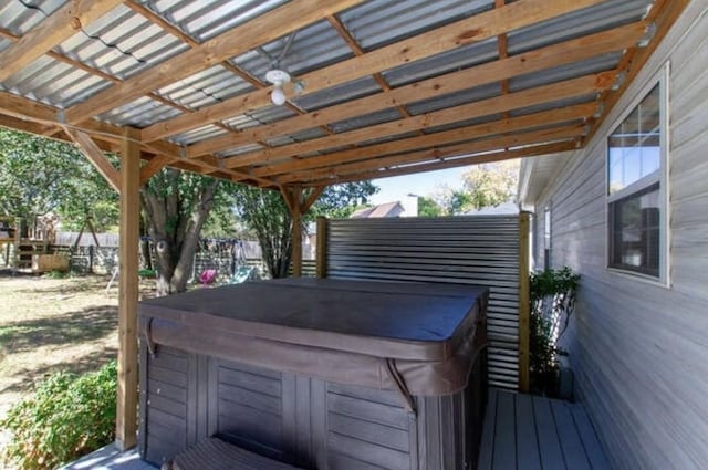 deck with a hot tub and fence