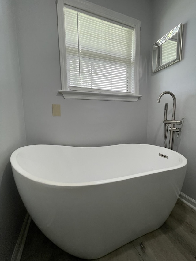 full bathroom with baseboards and a freestanding bath