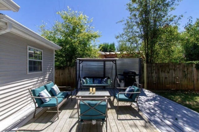 wooden terrace featuring an outdoor living space and a fenced backyard