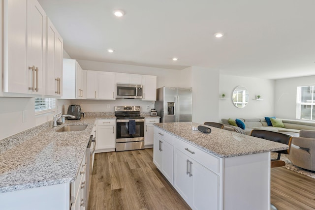 3008 Sapgate Ln, Nashville, TN 37207 - kitchen featuring light wood finished floors, a sink, a center island, and appliances with stainless steel finishes