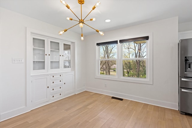 276 E Porters Bluff Rd E, Clarksville, TN 37040 - unfurnished dining area featuring baseboards, light wood-style floors, a chandelier, and visible vents