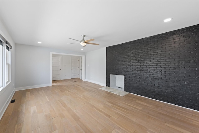 276 E Porters Bluff Rd E, Clarksville, TN 37040 - empty room with baseboards, ceiling fan, light wood-type flooring, and brick wall