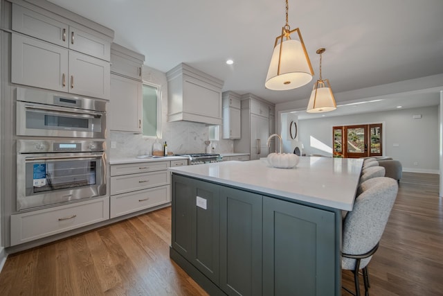 1405 Ashwood Ave, Nashville, TN 37212 - kitchen featuring open floor plan, light countertops, a breakfast bar, double oven, and decorative backsplash
