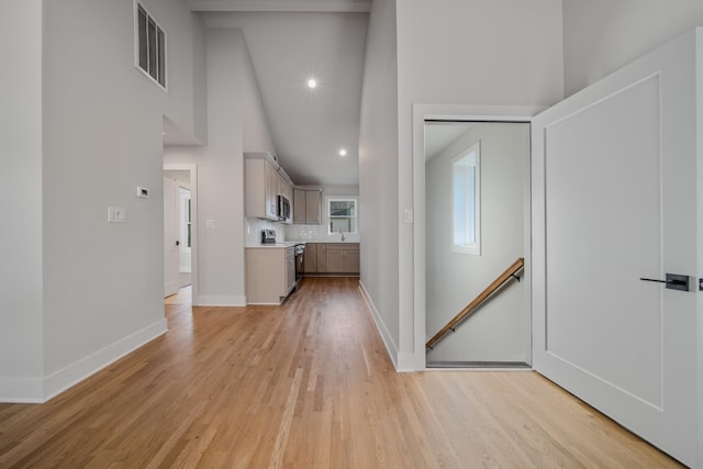 1405 Ashwood Ave, Nashville, TN 37212 - hallway featuring a towering ceiling, baseboards, an upstairs landing, light wood-style floors, and visible vents