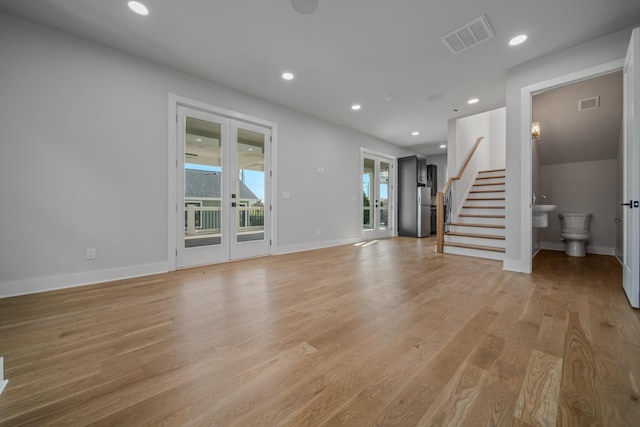 1405 Ashwood Ave, Nashville, TN 37212 - unfurnished living room featuring light wood-type flooring, recessed lighting, stairway, french doors, and visible vents