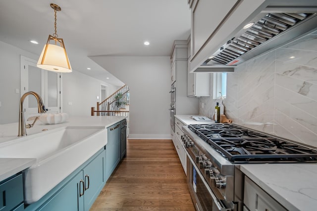 1405 Ashwood Ave, Nashville, TN 37212 - kitchen with blue cabinets, wood finished floors, a sink, appliances with stainless steel finishes, and premium range hood