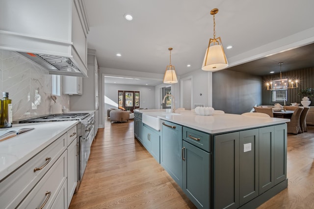 1405 Ashwood Ave, Nashville, TN 37212 - kitchen with light wood-type flooring, a chandelier, appliances with stainless steel finishes, a sink, and open floor plan