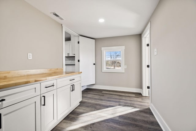 2999 Fayetteville Hwy, Belfast, TN 37019 - kitchen with dark wood-type flooring, baseboards, white cabinetry, and visible vents