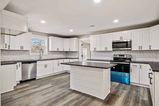 2999 Fayetteville Hwy, Belfast, TN 37019 - kitchen with dark countertops, stainless steel appliances, visible vents, white cabinets, and dark wood-style flooring