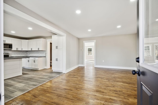 2999 Fayetteville Hwy, Belfast, TN 37019 - interior space with open floor plan, tasteful backsplash, stainless steel microwave, dark countertops, and light wood finished floors