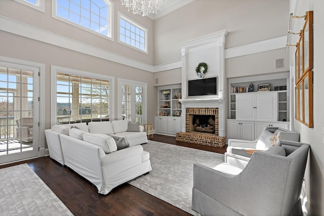 4 Colonel Winstead Dr, Brentwood, TN 37027 - living room featuring crown molding, an inviting chandelier, a towering ceiling, a brick fireplace, and dark wood-type flooring