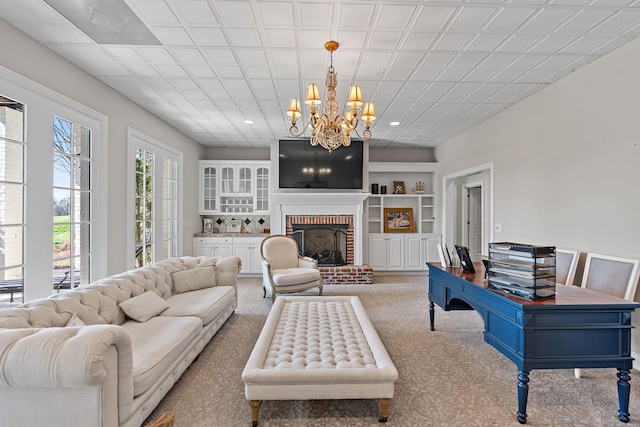 4 Colonel Winstead Dr, Brentwood, TN 37027 - living room featuring a fireplace, built in features, an inviting chandelier, and light colored carpet