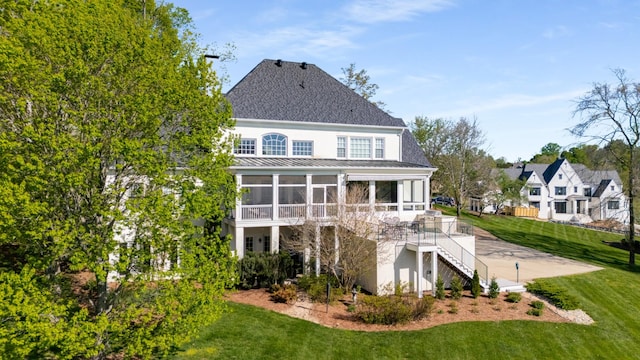 4 Colonel Winstead Dr, Brentwood, TN 37027 - back of property featuring stairway, a standing seam roof, a lawn, a sunroom, and metal roof