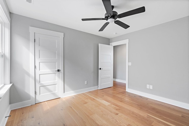 unfurnished bedroom featuring light wood finished floors, baseboards, and a ceiling fan