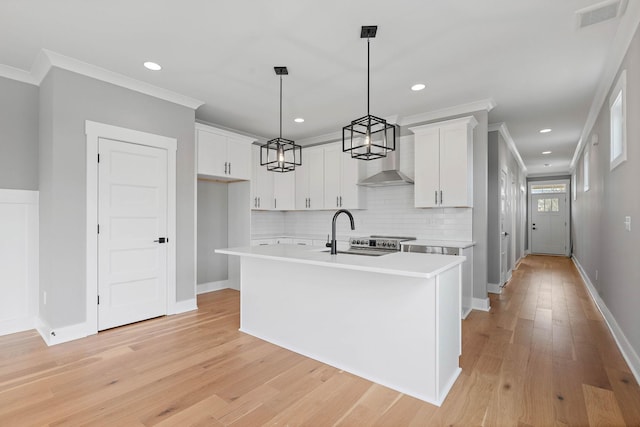kitchen featuring light countertops, a sink, crown molding, and visible vents