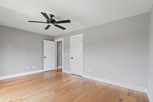 spare room featuring baseboards, ceiling fan, and light wood-type flooring