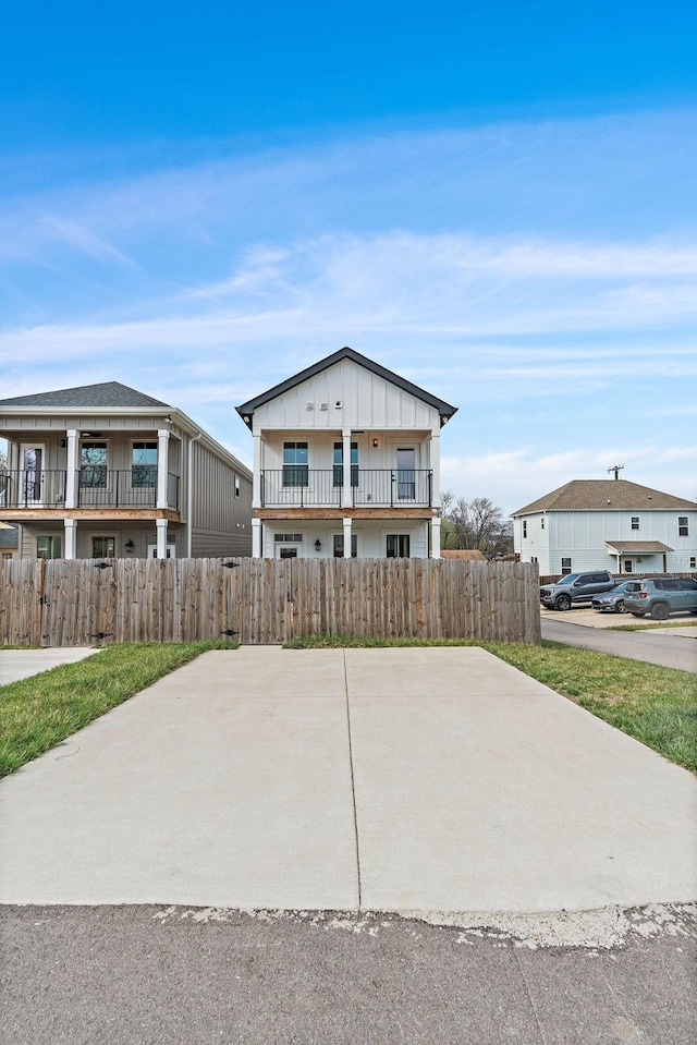 view of front of property with a balcony, fence, and board and batten siding