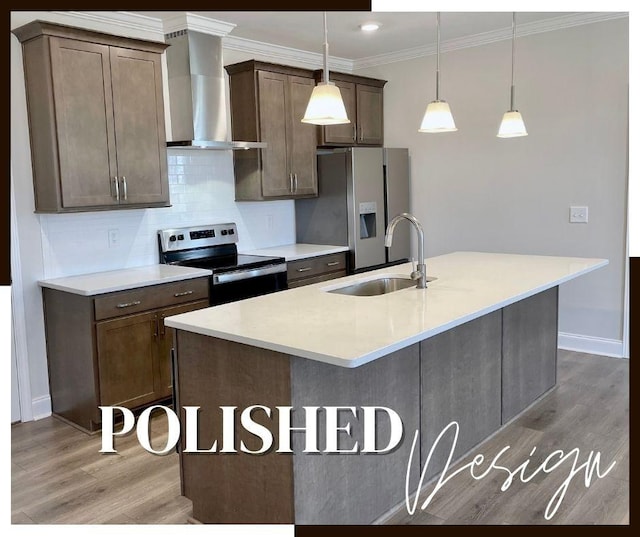 kitchen featuring a kitchen island with sink, wall chimney exhaust hood, stainless steel appliances, tasteful backsplash, and a sink