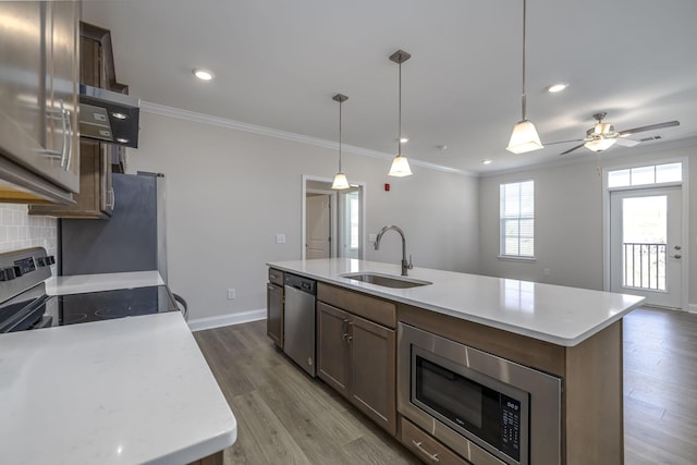 kitchen featuring appliances with stainless steel finishes, tasteful backsplash, dark wood finished floors, and a sink