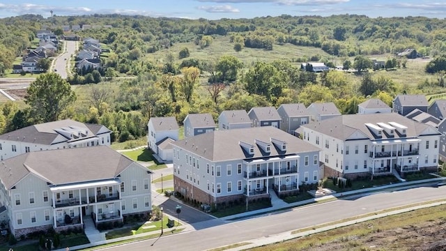 drone / aerial view featuring a residential view and a wooded view