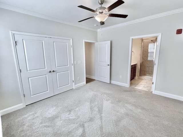 unfurnished bedroom with a closet, baseboards, crown molding, and light carpet