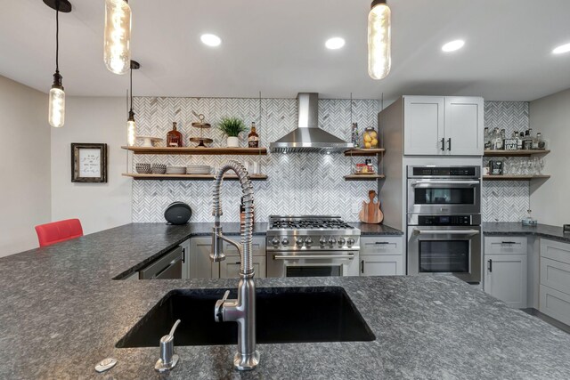 kitchen featuring tasteful backsplash, open shelves, pendant lighting, wall chimney exhaust hood, and appliances with stainless steel finishes