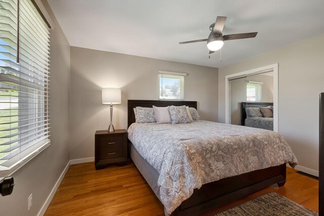 bedroom with a closet, baseboards, a ceiling fan, and light wood-type flooring