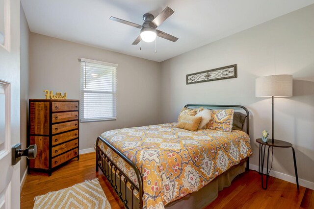 bedroom featuring baseboards, a ceiling fan, and wood finished floors