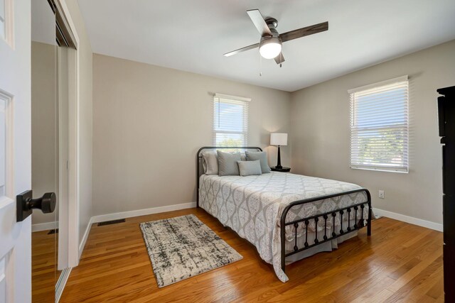 bedroom featuring visible vents, a ceiling fan, a closet, baseboards, and light wood-style flooring