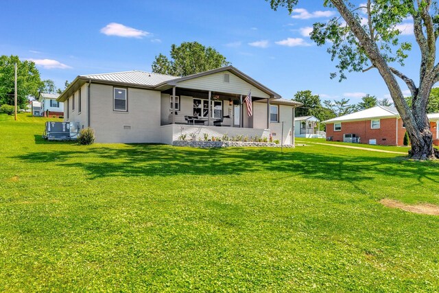 back of property featuring a lawn, metal roof, and covered porch
