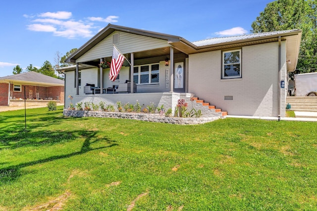 view of front of property featuring brick siding, a porch, a front yard, and metal roof
