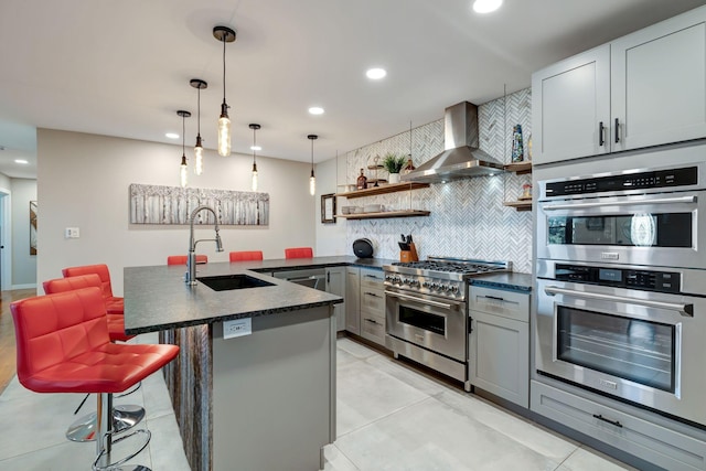 kitchen with stainless steel appliances, recessed lighting, tasteful backsplash, and wall chimney range hood