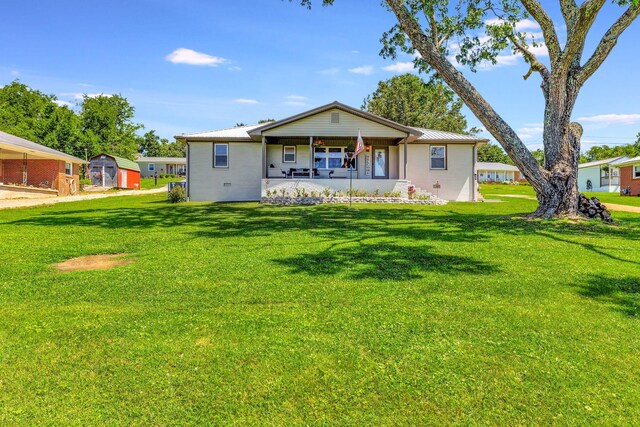 rear view of property featuring a yard, a porch, and metal roof