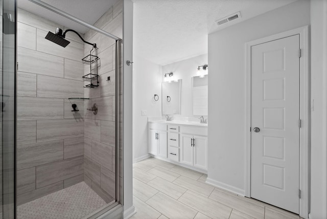 221 Wesson Dr, Clarksville, TN 37043 - bathroom featuring a textured ceiling, a sink, a stall shower, visible vents, and double vanity