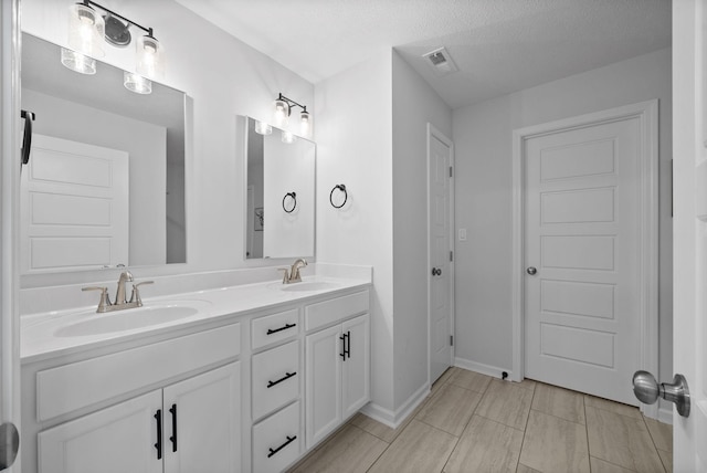 221 Wesson Dr, Clarksville, TN 37043 - full bathroom with double vanity, visible vents, a sink, and a textured ceiling