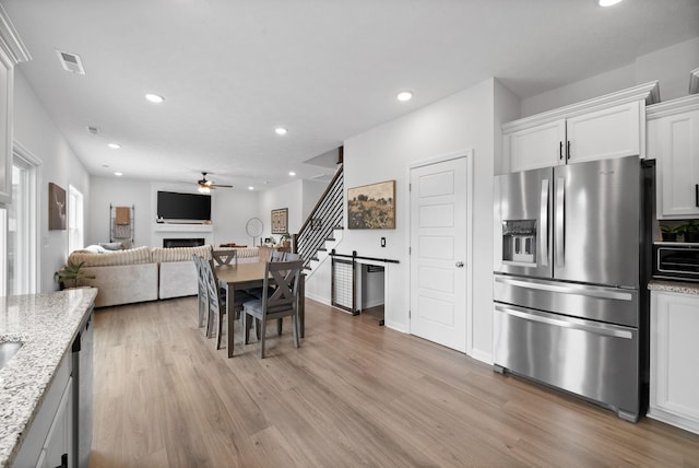 221 Wesson Dr, Clarksville, TN 37043 - kitchen featuring a ceiling fan, light wood finished floors, appliances with stainless steel finishes, white cabinets, and recessed lighting