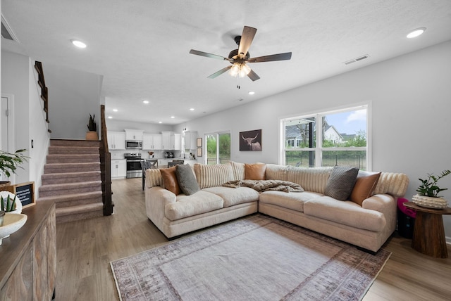 221 Wesson Dr, Clarksville, TN 37043 - living area featuring stairs, visible vents, light wood finished floors, and ceiling fan