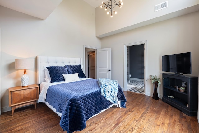 924 Gilmore Ave, Nashville, TN 37204 - bedroom with baseboards, a chandelier, a towering ceiling, visible vents, and wood finished floors