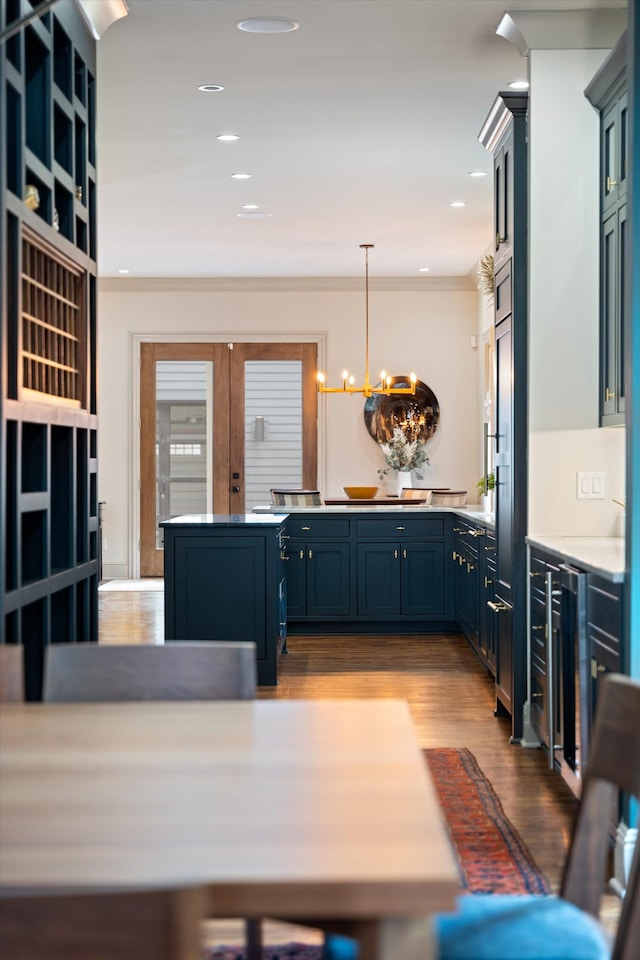 924 Gilmore Ave, Nashville, TN 37204 - kitchen with a peninsula, crown molding, wood finished floors, blue cabinetry, and a notable chandelier