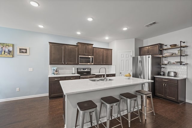 1424 Old Stone Rd NW, Lebanon, TN 37087 - kitchen with a breakfast bar, appliances with stainless steel finishes, visible vents, decorative backsplash, and dark brown cabinets