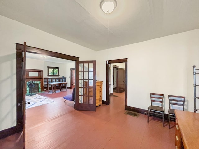 interior space featuring french doors, baseboards, and wood finished floors
