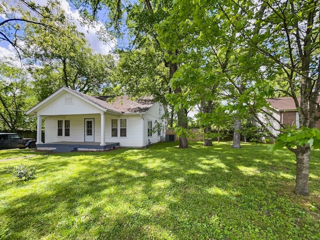 exterior space with a lawn, a shingled roof, and a porch