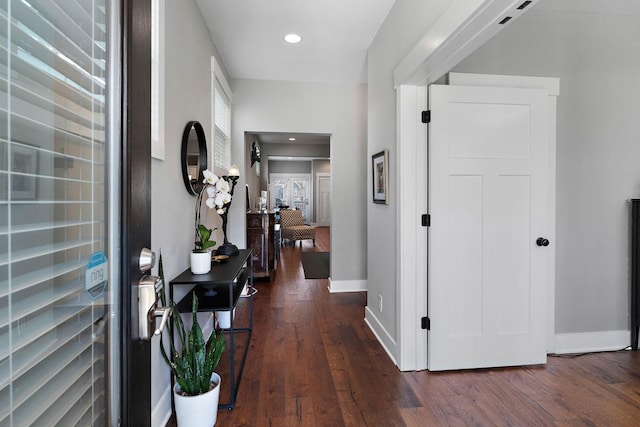 corridor featuring dark wood-style floors, baseboards, and recessed lighting