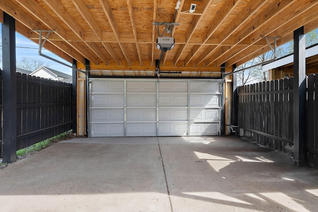 garage featuring a garage door opener and fence