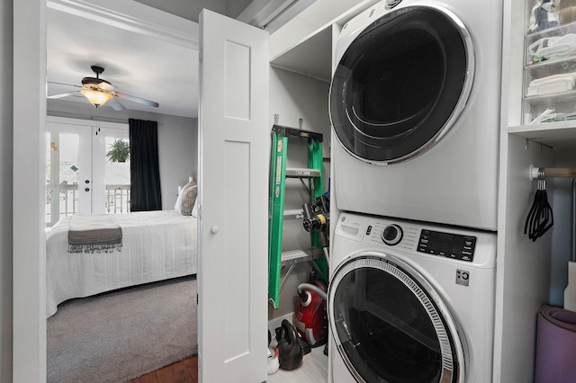 washroom with stacked washer and clothes dryer, ceiling fan, laundry area, and carpet