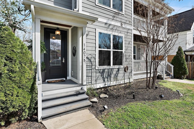view of exterior entry featuring covered porch